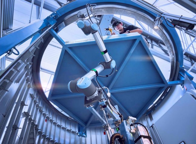 Wissenschaftler forscht zusammen mit Roboterarm