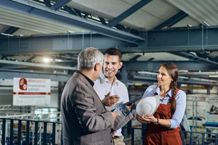 Two employees inform visitors