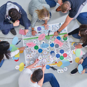 Leute arbeiten gemeinsam auf dem Boden an Projekt